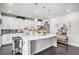 Modern kitchen with white cabinets, quartz countertops, stainless steel appliances, and a large island for meal preparation at 25064 E Archer Pl, Aurora, CO 80018