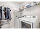 Efficient laundry room with modern appliances, built-in shelving, and ample storage space at 25064 E Archer Pl, Aurora, CO 80018