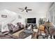 Spacious living room with leather seating, a ceiling fan, and staircase access at 25064 E Archer Pl, Aurora, CO 80018