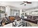 Elegant living room featuring comfortable leather couches, neutral color palette, and bright window lighting at 25064 E Archer Pl, Aurora, CO 80018