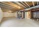 Unfinished basement area with exposed ceiling beams, equipment, and ample room for storage at 19131 E 65Th Ave, Denver, CO 80249