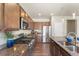 This kitchen features stainless appliances, granite countertops, breakfast bar seating, and lovely wood flooring at 19131 E 65Th Ave, Denver, CO 80249