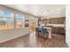 The bright open kitchen features stainless appliances, granite countertops, pendant lighting, and breakfast bar seating at 19131 E 65Th Ave, Denver, CO 80249