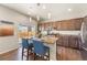 The open kitchen features stainless appliances, granite countertops, pendant lighting, and breakfast bar seating at 19131 E 65Th Ave, Denver, CO 80249