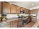 The kitchen is equipped with stainless appliances, granite countertops, and lovely wood flooring at 19131 E 65Th Ave, Denver, CO 80249