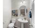 Modern powder room with a pedestal sink, an oval mirror, and stylish decor at 19131 E 65Th Ave, Denver, CO 80249