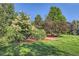 Backyard featuring lush lawn, mature trees, and mulched garden area at 5480 S Holly St, Greenwood Village, CO 80111