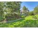 Well-maintained backyard with mature trees, green lawn, and a cozy deck at 5480 S Holly St, Greenwood Village, CO 80111