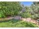 Stone steps lead to a secluded area of the backyard, surrounded by lush greenery and mature trees at 5480 S Holly St, Greenwood Village, CO 80111