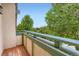 Inviting balcony with wood decking, painted railing, and lush green tree views at 5480 S Holly St, Greenwood Village, CO 80111