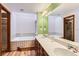 Large bathroom featuring double sinks, a soaking tub, and a neutral color scheme at 5480 S Holly St, Greenwood Village, CO 80111