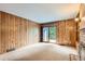 Cozy bedroom featuring wood paneling, a sliding glass door, and built-in shelving at 5480 S Holly St, Greenwood Village, CO 80111