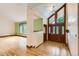 Bright foyer with hardwood floors, a wooden front door, and view of the adjoining living room at 5480 S Holly St, Greenwood Village, CO 80111