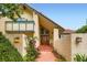 Home's exterior with a covered front entrance, decorative wood door, and manicured landscaping at 5480 S Holly St, Greenwood Village, CO 80111