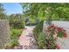 Charming walkway lined with lush greenery, vibrant flowers, and a decorative wall under a blue sky at 5480 S Holly St, Greenwood Village, CO 80111