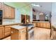 Bright kitchen featuring an island cooktop, granite counters, skylight and wood floors at 5480 S Holly St, Greenwood Village, CO 80111