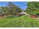 Well-manicured landscaping with lush greenery, mulch beds, and a glimpse of the house behind mature trees at 5480 S Holly St, Greenwood Village, CO 80111