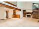 Open living room with a fireplace, built-in shelves, wooden beams and natural light at 5480 S Holly St, Greenwood Village, CO 80111