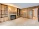 Living room with wood paneling, a fireplace, carpet, built-in shelves, and sconce lighting at 5480 S Holly St, Greenwood Village, CO 80111