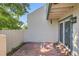 Exterior view of a concrete patio with partial wall, sliding glass door, and some greenery at 5480 S Holly St, Greenwood Village, CO 80111