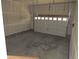 A spacious, two-car garage featuring gray concrete floors and white paneling at 4580 S Ukraine Cir, Aurora, CO 80015