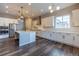 Open kitchen featuring white cabinets, modern appliances, an island with a sink, and stylish light fixtures at 4580 S Ukraine Cir, Aurora, CO 80015