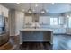 Well-lit kitchen with a large island, stainless steel appliances, and modern pendant lighting at 4580 S Ukraine Cir, Aurora, CO 80015