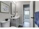 Well-lit bathroom with gray vanity and black hardware, accompanied by stylish decor and easy access to the bedroom at 3402 S Olathe Way, Aurora, CO 80013