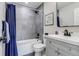Updated bathroom with gray tiling in shower/tub, modern vanity, and dark hardware offering a clean aesthetic at 3402 S Olathe Way, Aurora, CO 80013