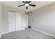 Comfortable bedroom with gray carpet, neutral walls, and a ceiling fan, plus a double door closet for storage at 3402 S Olathe Way, Aurora, CO 80013