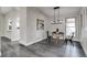 Dining area featuring modern light fixture, table with seating, and view to the kitchen at 3402 S Olathe Way, Aurora, CO 80013