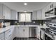 Updated kitchen features white cabinets, quartz countertops, and stainless steel appliances at 3402 S Olathe Way, Aurora, CO 80013