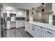 Bright kitchen boasts white cabinets, stylish hardware, and quartz countertops at 3402 S Olathe Way, Aurora, CO 80013