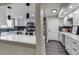 Open-concept kitchen with white cabinets, quartz countertops, dark backsplash, and stainless steel appliances for a modern look at 3402 S Olathe Way, Aurora, CO 80013