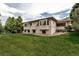 Picture of the rear of a two-story home with large windows and expansive green lawn at 6379 Spotted Fawn Run, Littleton, CO 80125