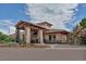 Clubhouse exterior with stone pillars, wood pergola, professional landscaping, and paved drive at 6379 Spotted Fawn Run, Littleton, CO 80125