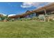 Large lawn overlooking the modern clubhouse exterior, highlighted by wood, stone, and professional landscaping at 6379 Spotted Fawn Run, Littleton, CO 80125