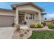 Stunning front entrance with an arched portico, landscaping and a three-car garage at 6379 Spotted Fawn Run, Littleton, CO 80125