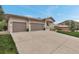 A three-car attached garage with a spacious driveway, and manicured front lawn at 6379 Spotted Fawn Run, Littleton, CO 80125
