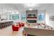 Open concept: Stone fireplace, large windows, seating, and kitchen island at 6379 Spotted Fawn Run, Littleton, CO 80125