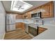 Well-lit kitchen features wooden cabinets, stainless steel appliances, and modern flooring at 13991 E Marina Dr # 505, Aurora, CO 80014