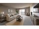 Inviting living room features a comfortable sectional sofa, neutral decor, and a sliding glass door at 13991 E Marina Dr # 505, Aurora, CO 80014