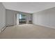 Well-lit living room features neutral carpet, radiator heating and a sliding glass door to the balcony at 13991 E Marina Dr # 505, Aurora, CO 80014