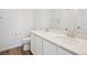 All white bathroom with double vanity, modern fixtures, toilet and wood style floors at 24707 E 40Th Ave, Aurora, CO 80019