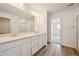 All white bathroom with double vanity, large mirror and modern fixtures at 24707 E 40Th Ave, Aurora, CO 80019