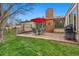 Back yard patio with a seating area, red umbrella and grill on a well-manicured lawn at 6305 W 6Th Ave # C17, Lakewood, CO 80214