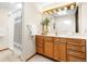 Bathroom with a single sink vanity, a large well-lit mirror and walk-in shower with light tile at 6305 W 6Th Ave # C17, Lakewood, CO 80214
