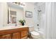 Brightly lit bathroom with wood cabinets and a shower-tub combination with white tiled walls at 6305 W 6Th Ave # C17, Lakewood, CO 80214