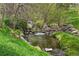 Peaceful creek with grassy banks and a wooden bench, perfect for enjoying nature at 6305 W 6Th Ave # C17, Lakewood, CO 80214