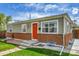 Inviting home featuring a brick foundation, neat landscaping, and a vibrant red door, blending comfort and style at 2850 Roosevelt, Thornton, CO 80229
